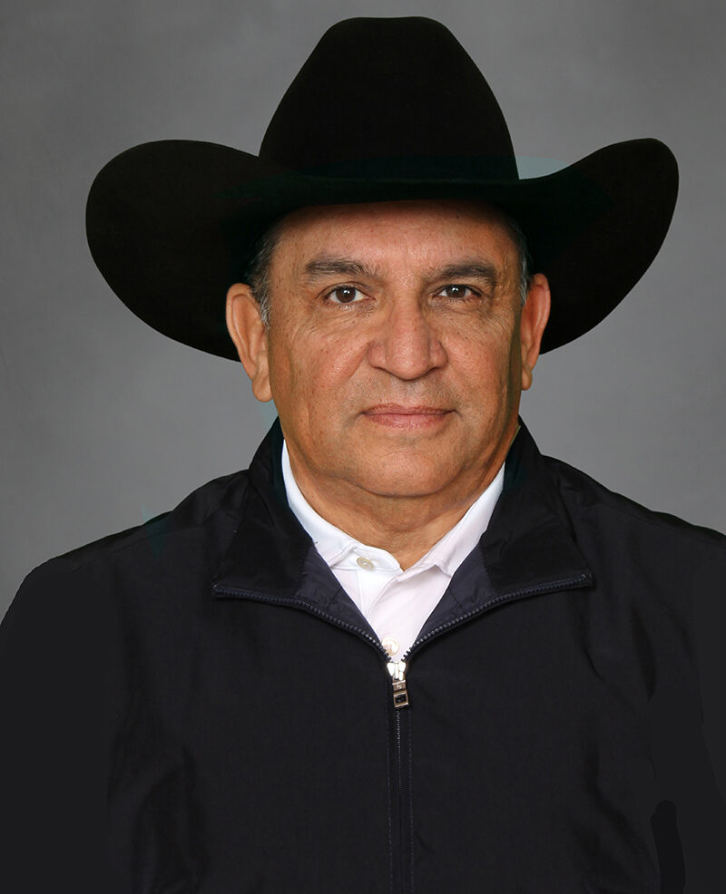 A man wearing a black cowboy hat and a black jacket over a white shirt poses in front of a plain gray background, echoing the bold spirit of Introducing MOSQUITOCON™: VM Products® Reveals Latest Innovation.